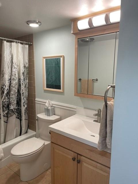 full bathroom featuring shower / tub combo with curtain, toilet, tile patterned flooring, and vanity