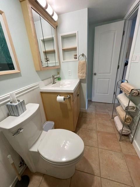 bathroom featuring toilet, tile patterned flooring, and vanity