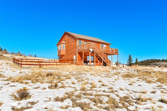 back of property featuring fence, a wooden deck, and stairway