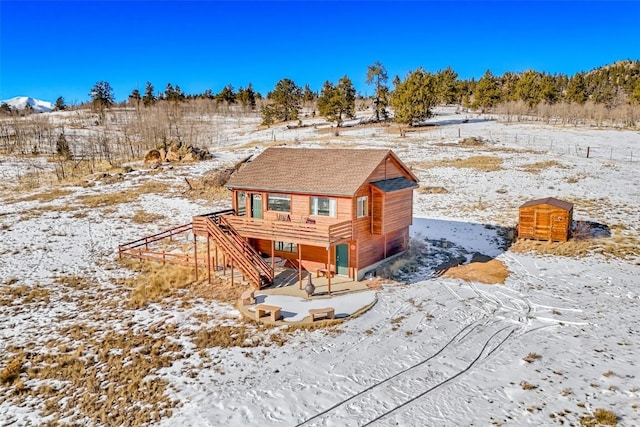 snow covered house featuring a shingled roof