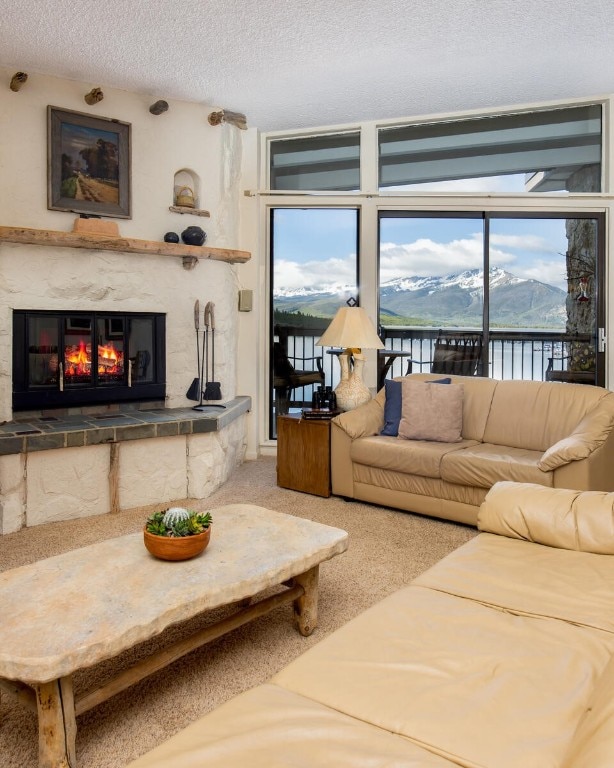 576 Tenderfoot St Unit 163, Dillon, CO 80435 - living area featuring carpet flooring, a high end fireplace, a water and mountain view, and a textured ceiling