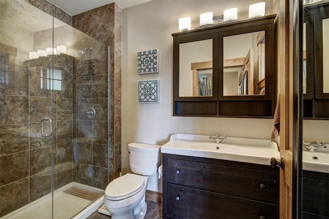 full bath featuring toilet, vanity, and a stall shower