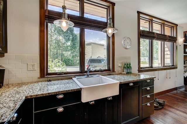 kitchen featuring dark wood finished floors, tasteful backsplash, a sink, and plenty of natural light
