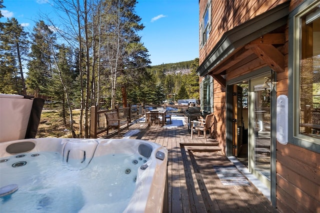 wooden deck featuring hot tub deck surround