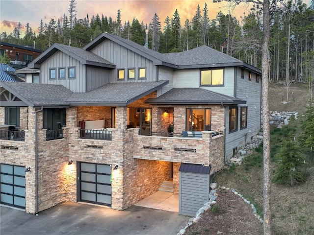 260 N Fuller Placer Rd, Breckenridge, CO 80424 - view of front facade with an attached garage, a shingled roof, driveway, board and batten siding, and stone siding