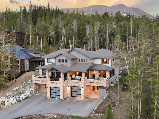 260 N Fuller Placer Rd, Breckenridge, CO 80424 - view of front of property featuring an attached garage, asphalt driveway, a forest view, a mountain view, and a shingled roof