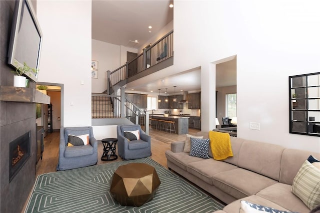 260 N Fuller Placer Rd, Breckenridge, CO 80424 - living room featuring wood finished floors, a towering ceiling, a fireplace, stairway, and recessed lighting
