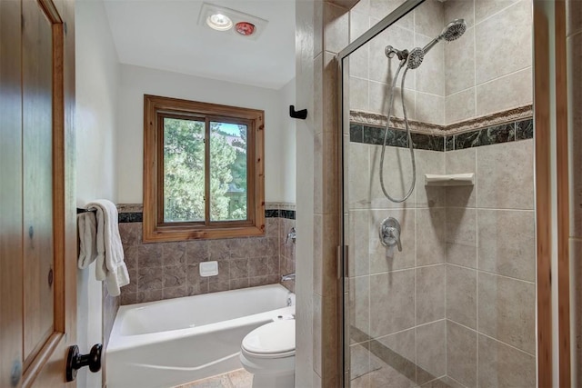 bathroom with a tub to relax in, a wainscoted wall, toilet, tile walls, and a stall shower