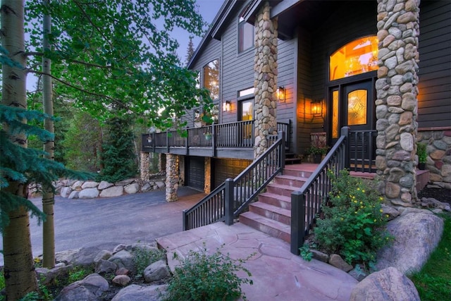 view of exterior entry featuring concrete driveway and an attached garage