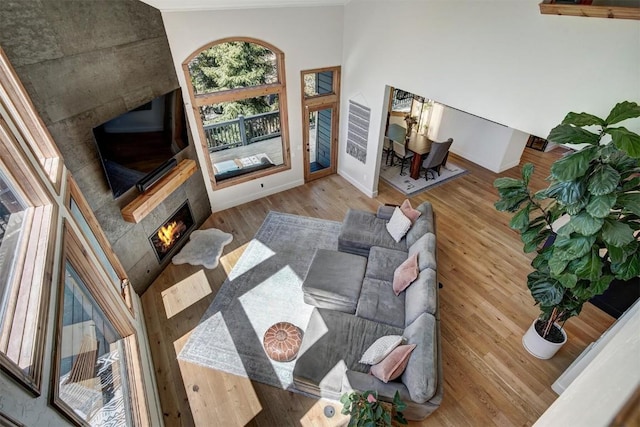 living area featuring baseboards, wood finished floors, and a tiled fireplace