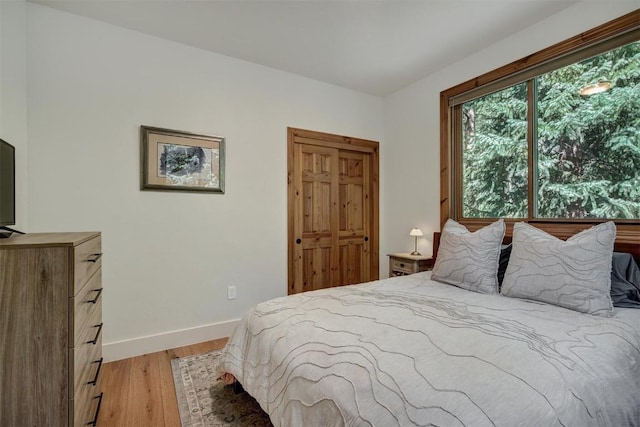 bedroom with light wood finished floors and baseboards
