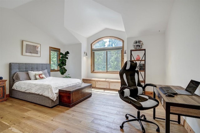bedroom with vaulted ceiling and light wood-style floors