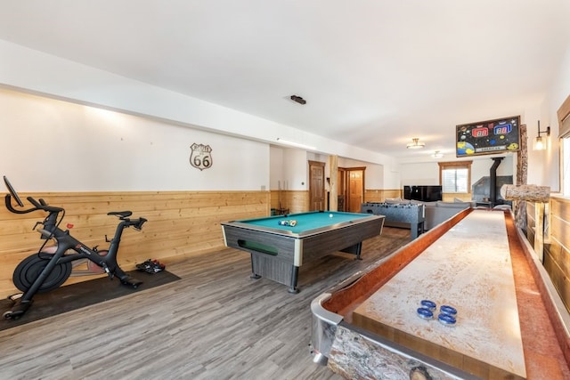 playroom featuring wood walls, billiards, wood finished floors, a wood stove, and wainscoting