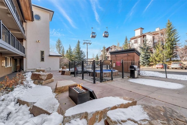 exterior space featuring fence, a patio, an outdoor fire pit, and a swimming pool