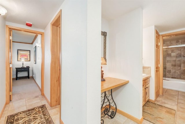 hallway featuring baseboards and light tile patterned floors