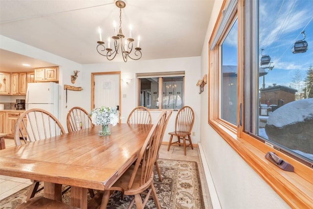 dining area with light tile patterned flooring, a baseboard radiator, baseboards, and an inviting chandelier