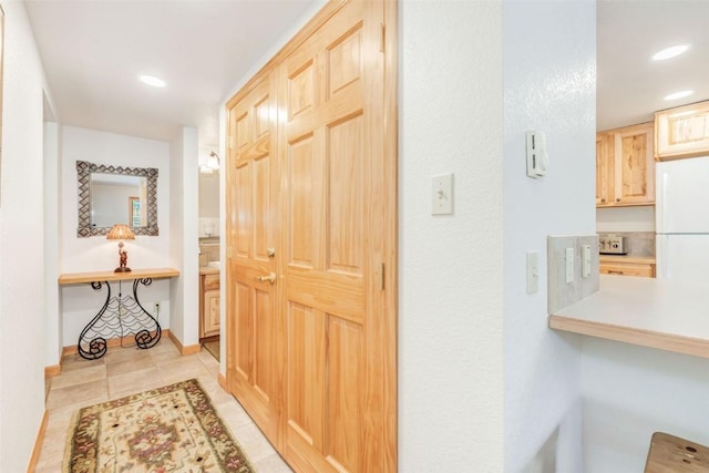 corridor with recessed lighting, baseboards, and light tile patterned flooring