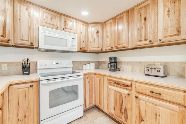 kitchen featuring light countertops, light brown cabinets, and white appliances