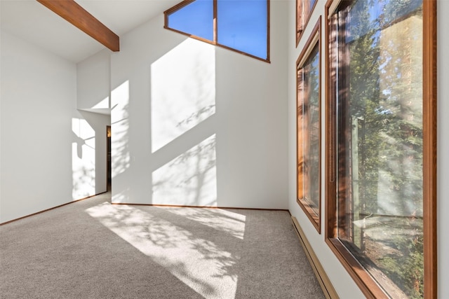 carpeted empty room with beam ceiling