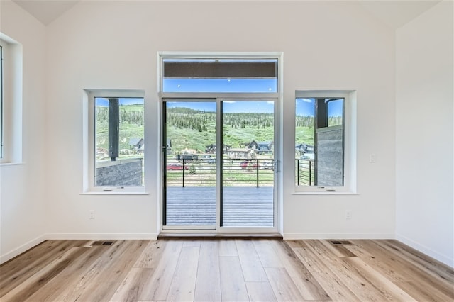 350 Stan Miller Unit 100, Breckenridge, CO 80424 - doorway to outside with lofted ceiling, light wood-type flooring, and baseboards