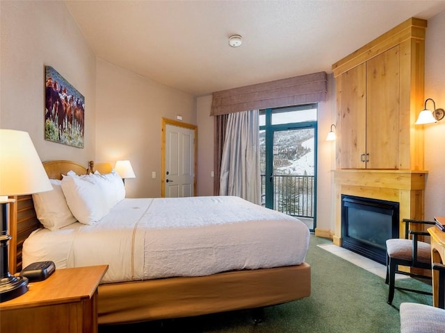 carpeted bedroom featuring a fireplace with flush hearth and access to exterior