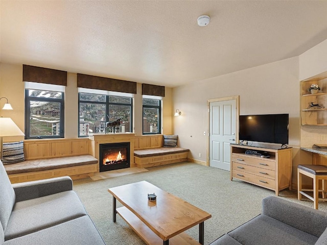 living room featuring carpet flooring and a lit fireplace