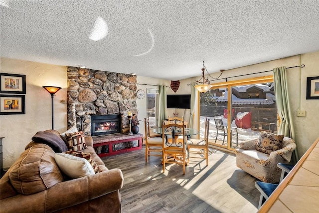 living area with a fireplace, wood finished floors, and a textured ceiling