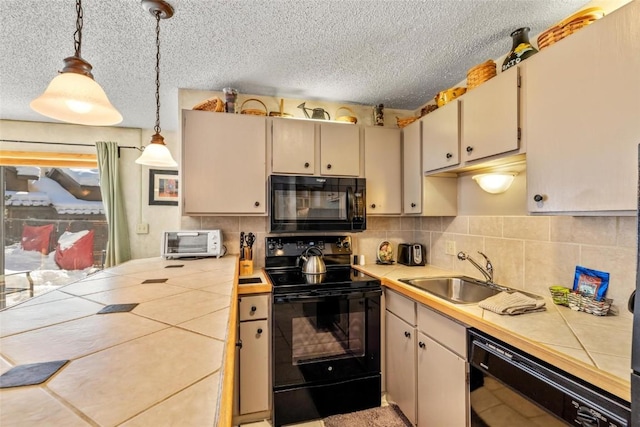kitchen with a textured ceiling, a sink, tile countertops, and black appliances
