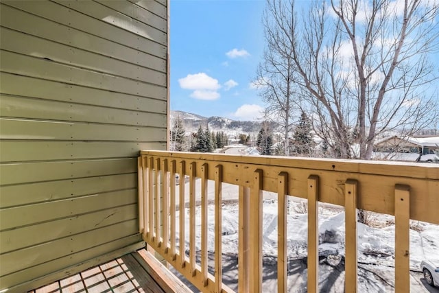 snow covered back of property featuring a mountain view