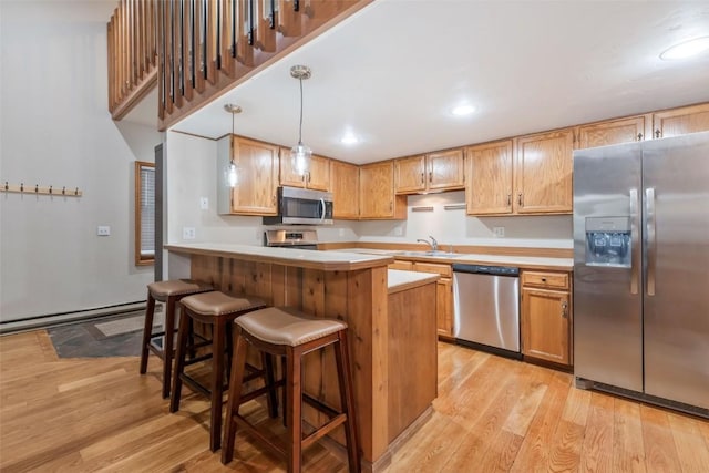 2915 Chinook Ln Unit B22, Steamboat Springs, CO 80487 - kitchen with stainless steel appliances, light wood-style flooring, light countertops, a breakfast bar, and a sink