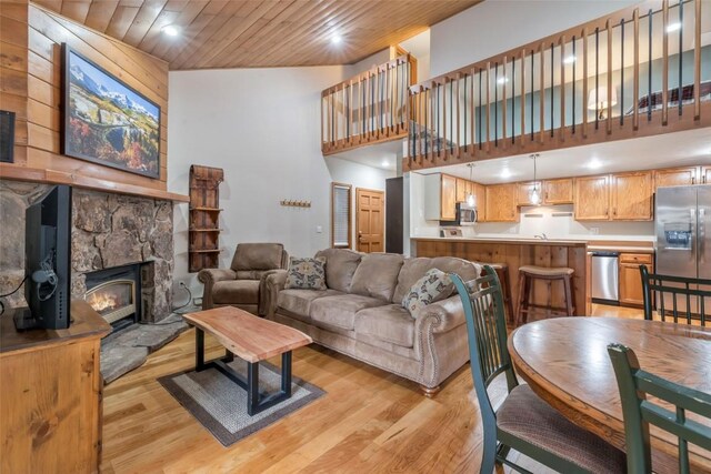 2915 Chinook Ln Unit B22, Steamboat Springs, CO 80487 - living room with a towering ceiling, light wood-type flooring, recessed lighting, wooden ceiling, and a stone fireplace