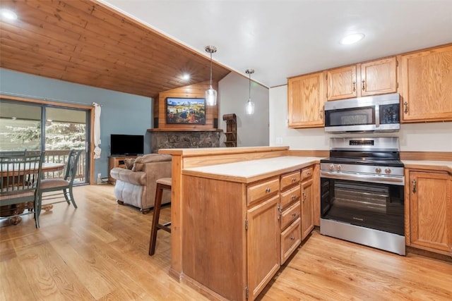 2915 Chinook Ln Unit B22, Steamboat Springs, CO 80487 - kitchen featuring stainless steel appliances, a peninsula, light wood-style floors, lofted ceiling, and a breakfast bar