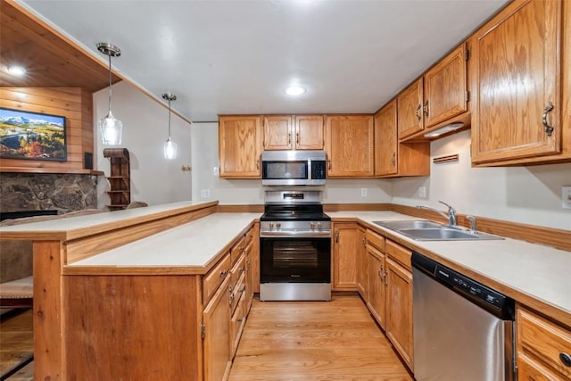 2915 Chinook Ln Unit B22, Steamboat Springs, CO 80487 - kitchen with stainless steel appliances, a sink, a peninsula, light wood-style flooring, and light countertops