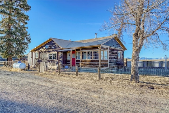 single story home featuring metal roof and fence private yard