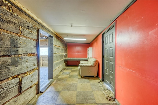 hall with wood walls and tile patterned floors
