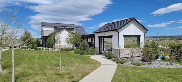 9279 Merino Ct # B, Littleton, CO 80125 - view of front of house featuring a standing seam roof, a front lawn, board and batten siding, stone siding, and a metal roof