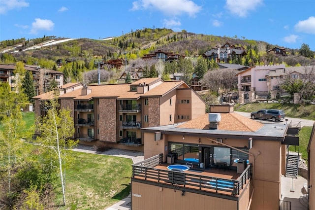 rear view of property with a mountain view, a residential view, and a balcony
