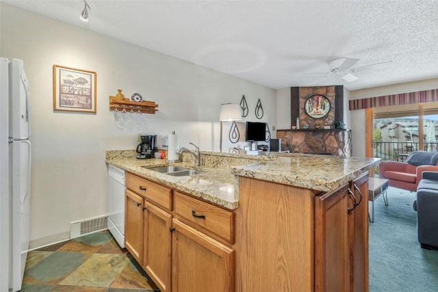 kitchen with a sink, white appliances, a peninsula, and open floor plan