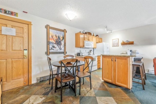 kitchen with white appliances, a textured ceiling, a peninsula, light countertops, and decorative backsplash