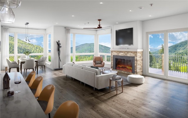 living room with a glass covered fireplace, a ceiling fan, wood finished floors, and recessed lighting