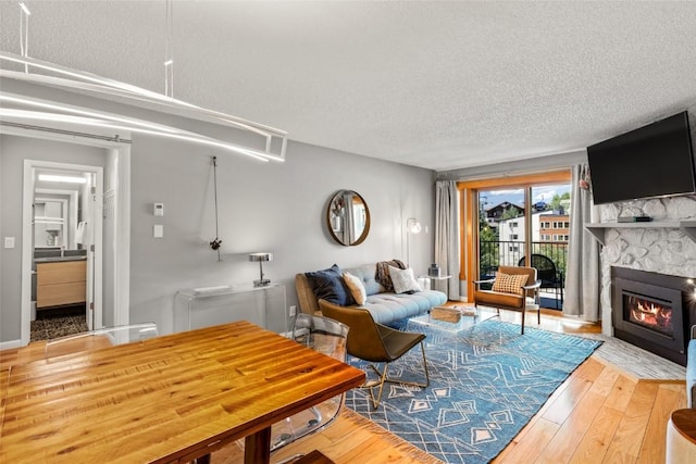 2350 Ski Trail Ln Unit 112, Steamboat Springs, CO 80487 - living area with a textured ceiling, hardwood / wood-style flooring, and a stone fireplace