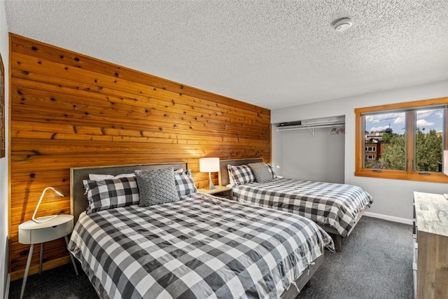 2350 Ski Trail Ln Unit 112, Steamboat Springs, CO 80487 - carpeted bedroom featuring a textured ceiling and wood walls