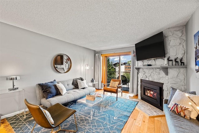 2350 Ski Trail Ln Unit 112, Steamboat Springs, CO 80487 - living room featuring a textured ceiling, a fireplace, and wood finished floors