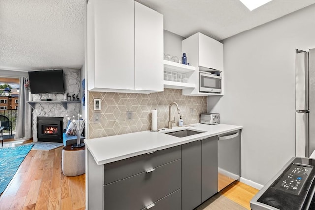 2350 Ski Trail Ln Unit 112, Steamboat Springs, CO 80487 - kitchen featuring stainless steel appliances, light wood-style flooring, gray cabinetry, white cabinets, and a textured ceiling