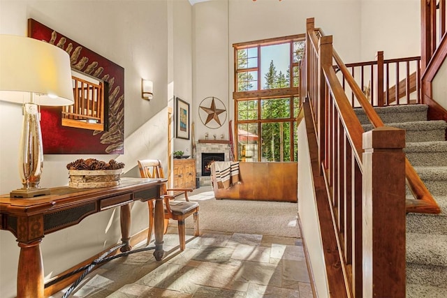 366 Moonstone Rd, Breckenridge, CO 80424 - stairway featuring stone tile floors, a high ceiling, a stone fireplace, and carpet flooring