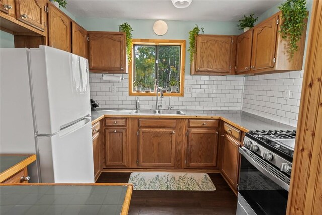465 Mount Guyot Cir, Jefferson, CO 80456 - kitchen with brown cabinetry, dark wood-style flooring, stainless steel gas stove, a sink, and freestanding refrigerator