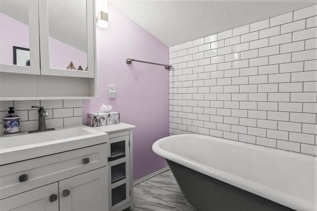 465 Mount Guyot Cir, Jefferson, CO 80456 - full bathroom featuring vanity, marble finish floor, a textured ceiling, a soaking tub, and backsplash