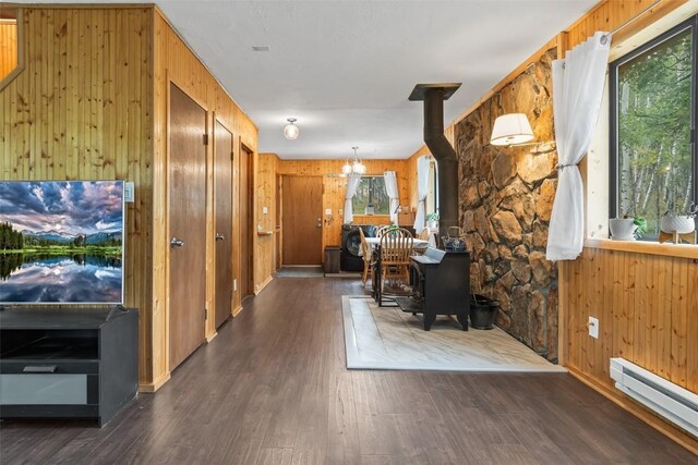 465 Mount Guyot Cir, Jefferson, CO 80456 - office space featuring a wood stove, wooden walls, baseboard heating, dark wood-type flooring, and a notable chandelier