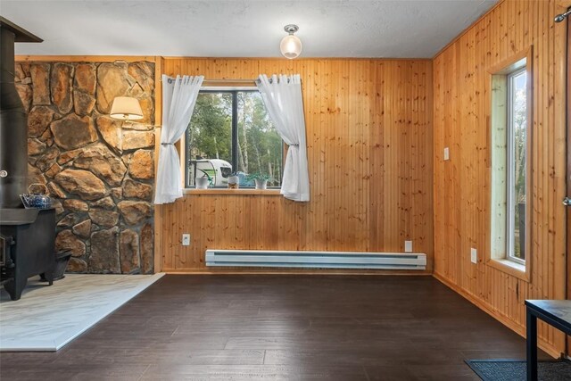 465 Mount Guyot Cir, Jefferson, CO 80456 - interior space with a wood stove, wood walls, hardwood / wood-style floors, baseboards, and baseboard heating