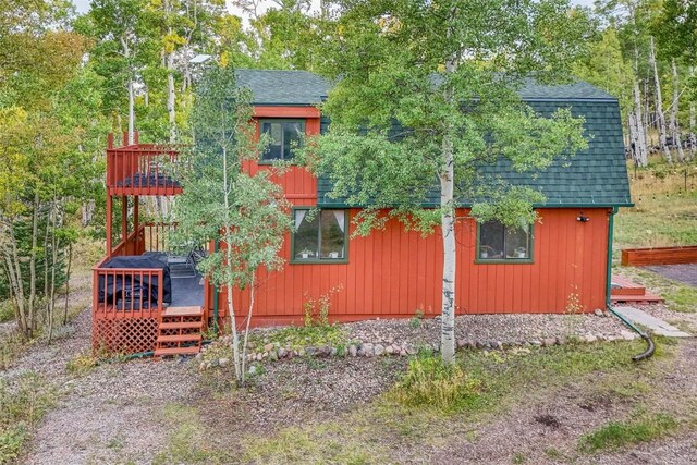 465 Mount Guyot Cir, Jefferson, CO 80456 - view of side of home featuring a shingled roof and a wooden deck